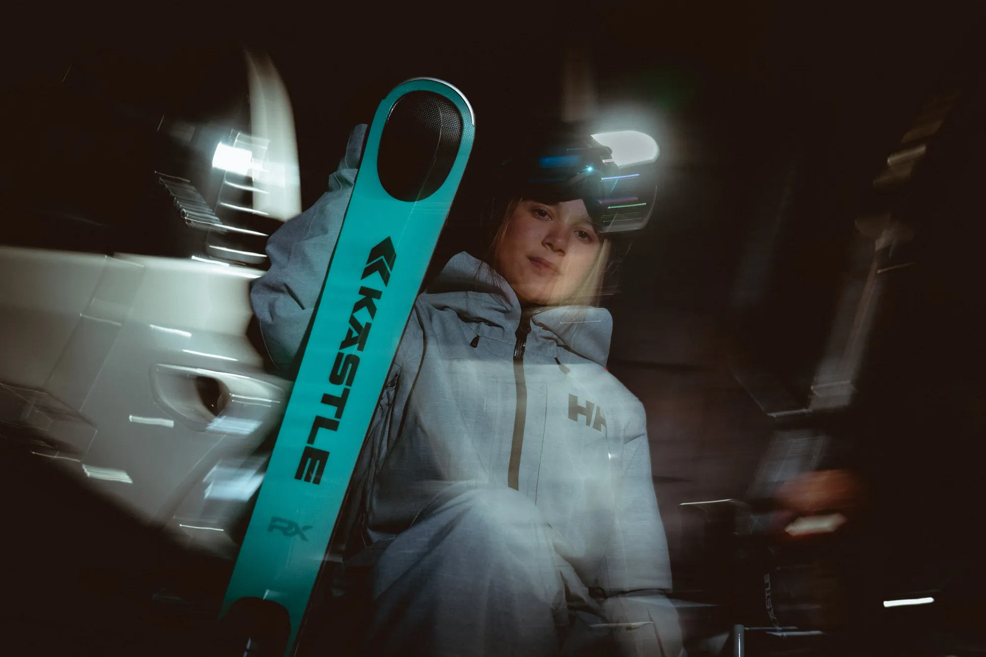 Skier holding Kästle skis at night